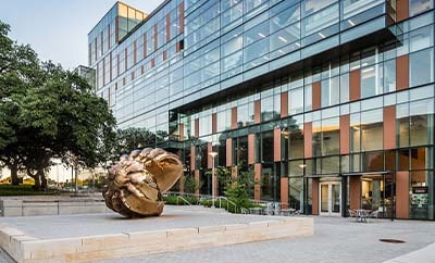 A view of Dell Medical School's Health Learning Building, including a conch shell art structure.