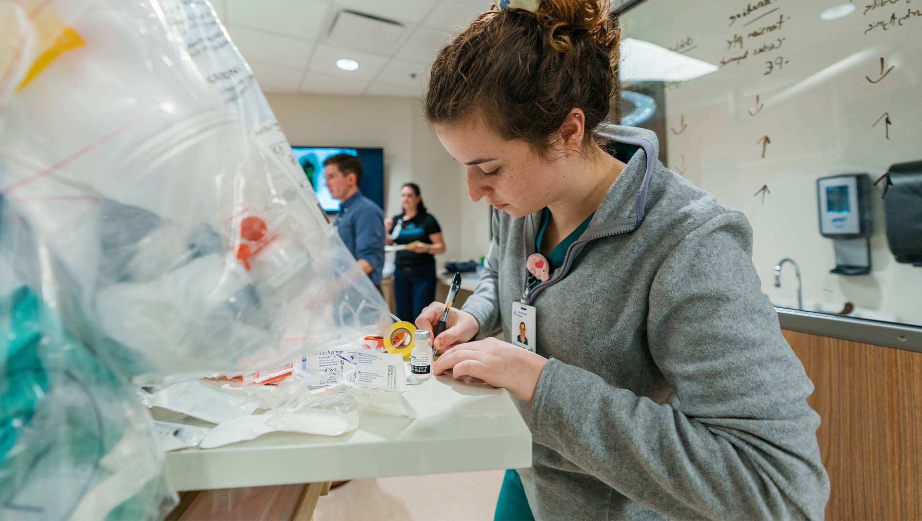 A woman takes notes by a crash cart inside the Dell Children's Simulation Center.