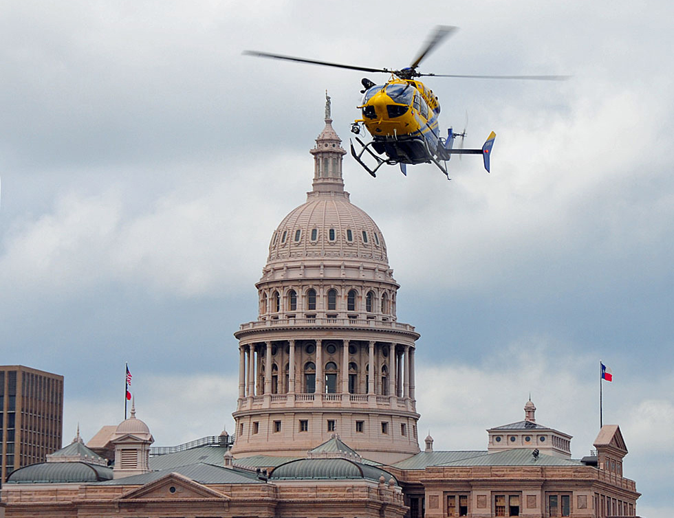 EMS helicopter flying in front of the Texas Capitol.