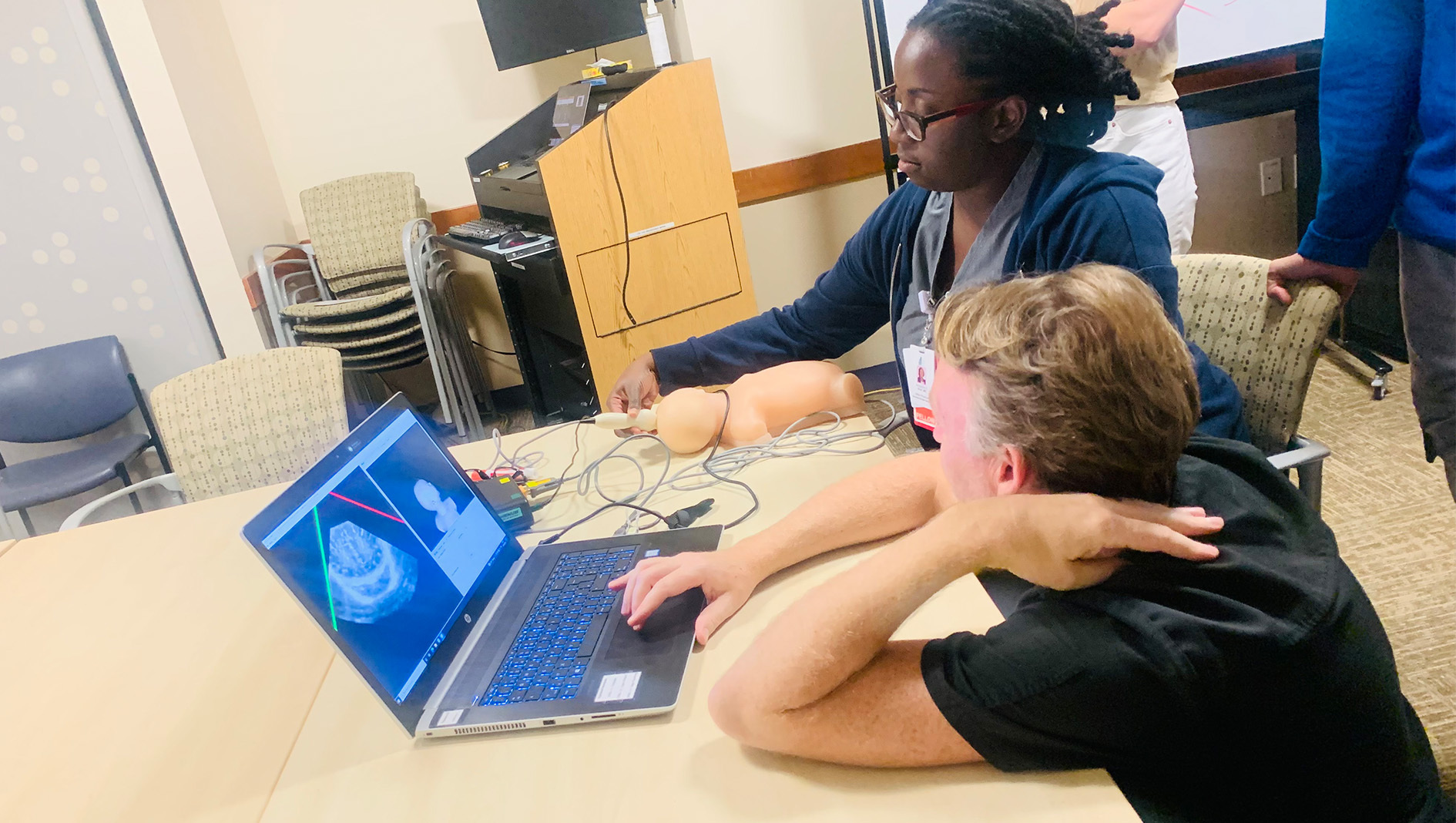 A medical trainee engages in an ultrasound activity on a laptop.