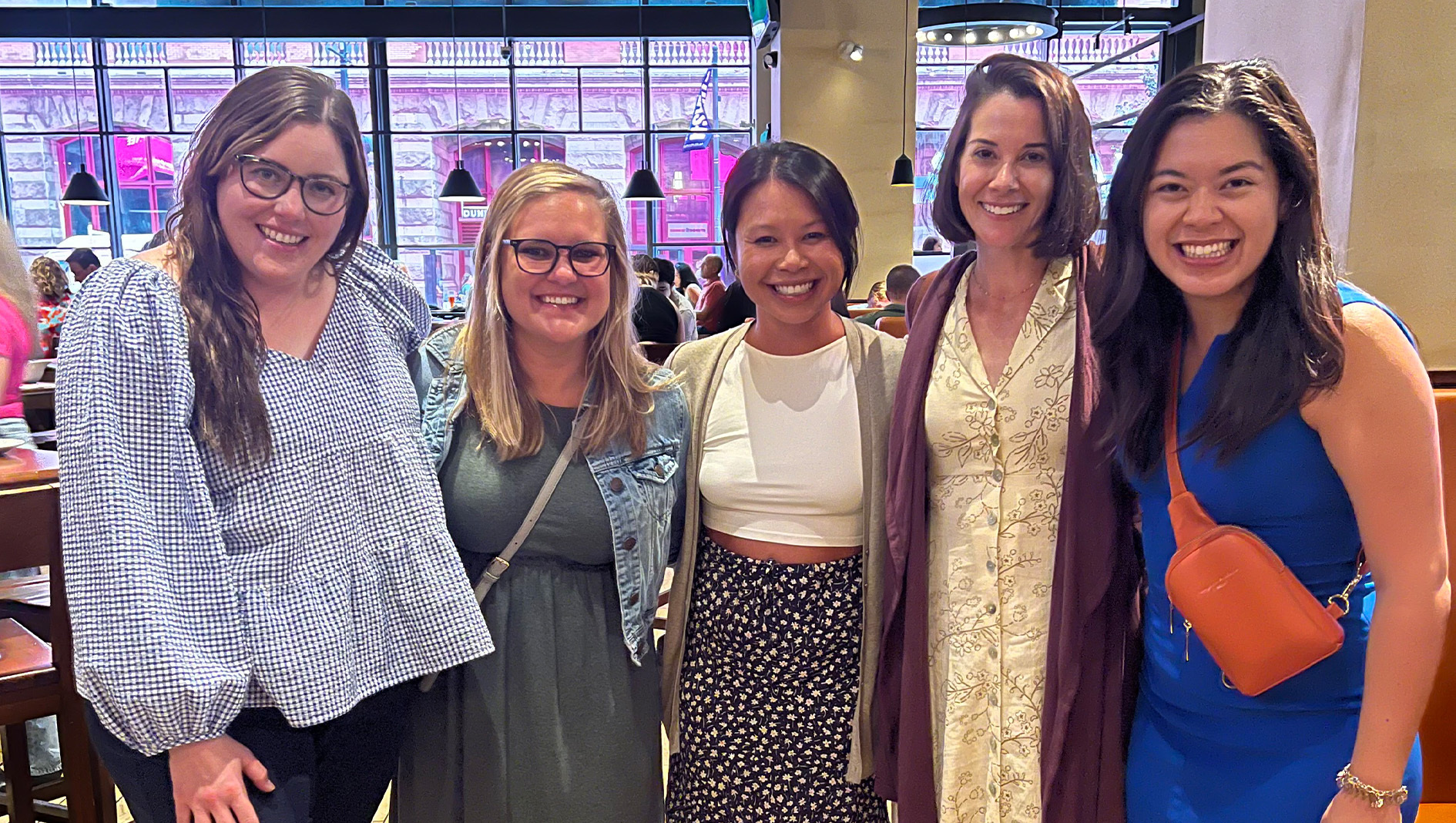 Four women within the Pediatric Hospital Medicine Fellowship stand together for a group photo at a social event.