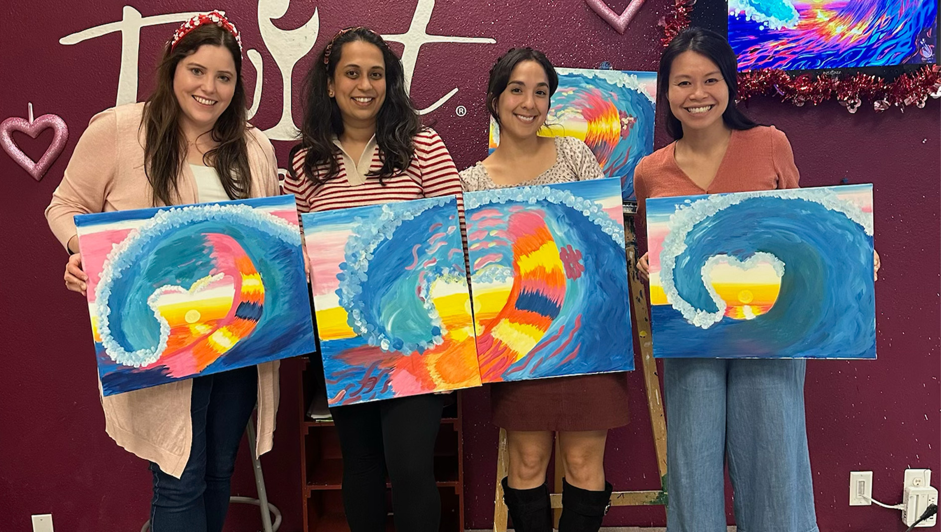 Four trainees within the Pediatric Hospital Medicine Fellowship hold paintings that they made.
