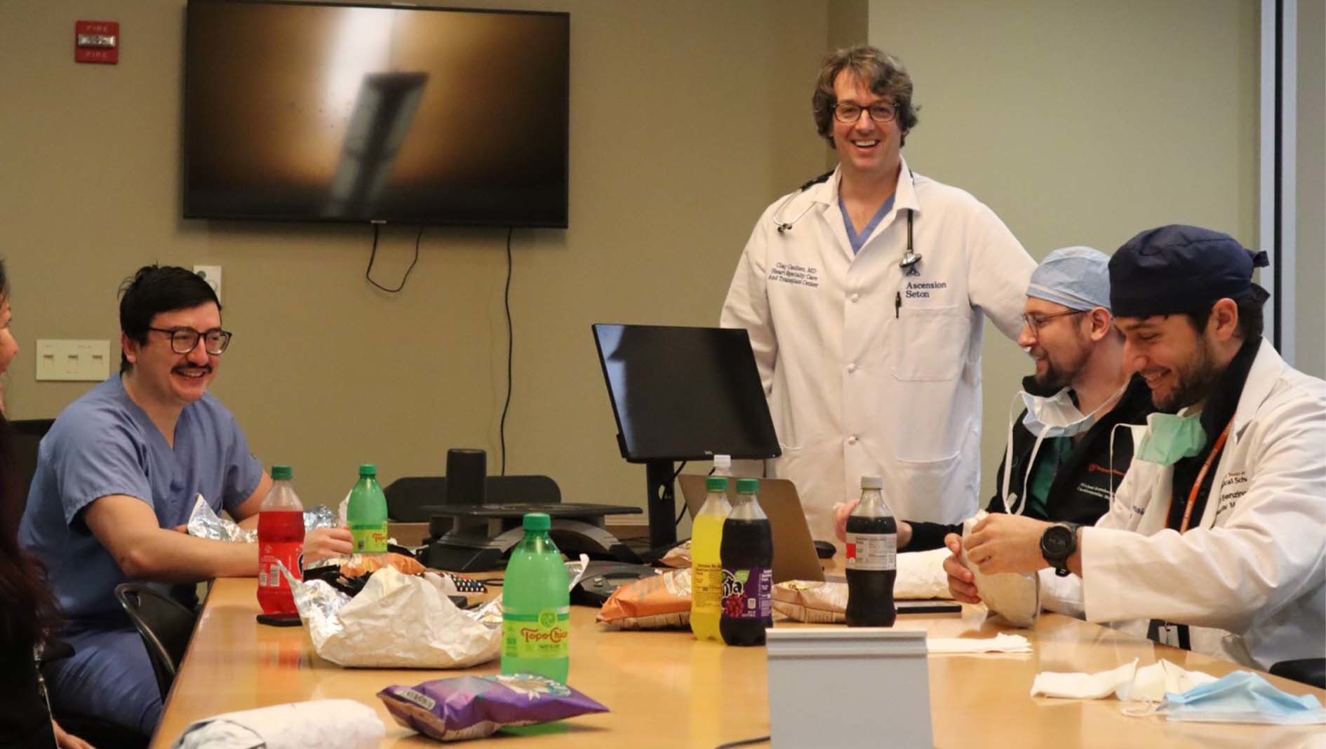 Members of a the Cardiovascular Disease Fellowship have lunch in a conference room.