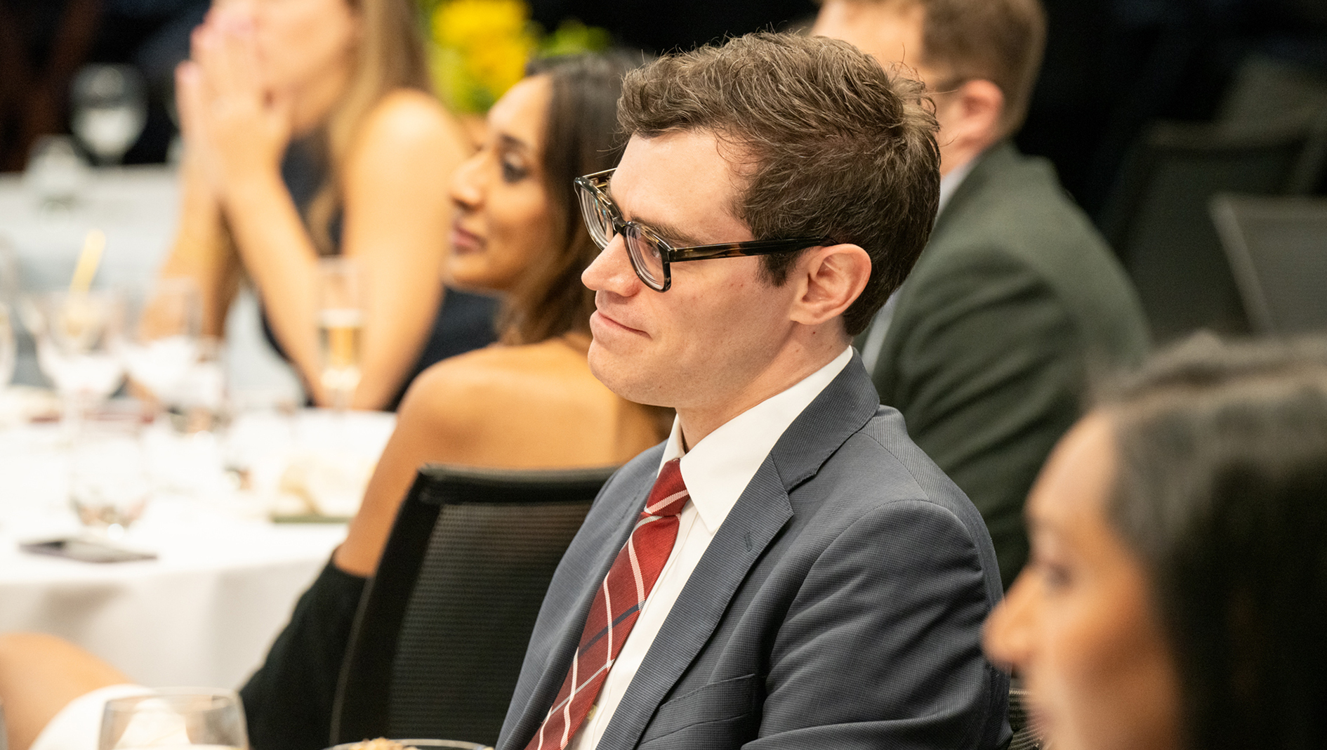 A member of the Interventional Cardiology fellowship listens to a speaker at graduation.