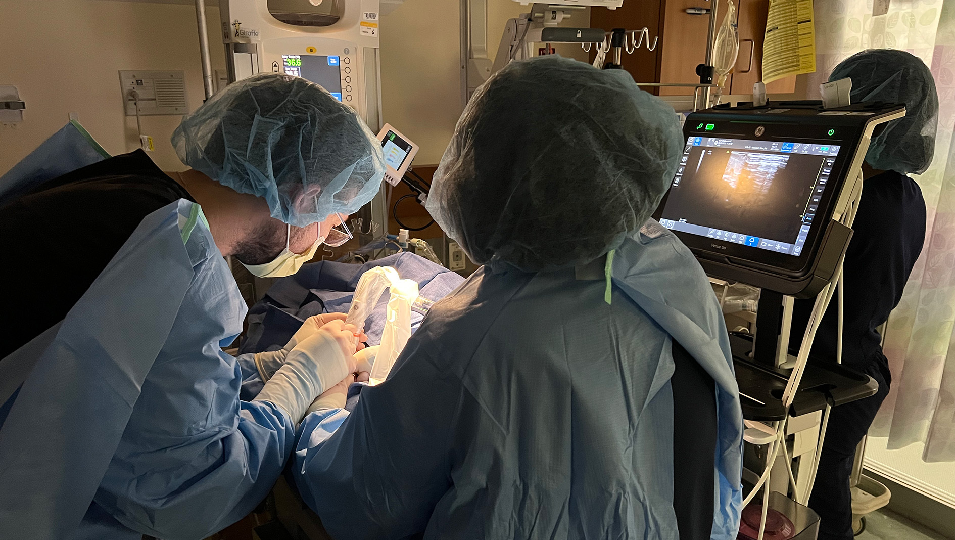 A group of NICU fellows perform a procedure.