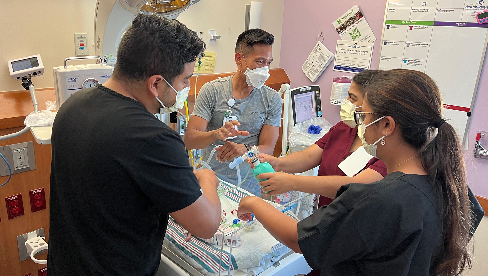A NICU fellow works with a faculty member to practice a procedure.