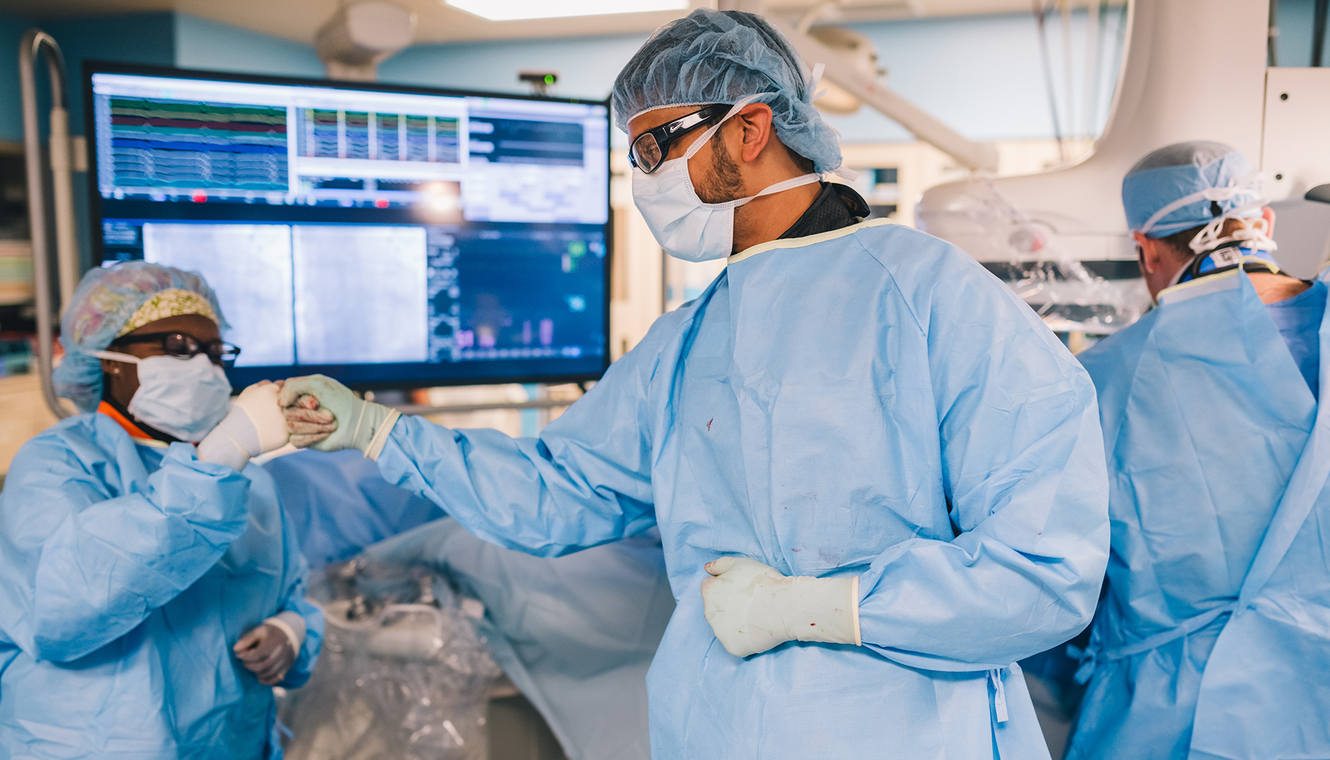 Providers fist bump after completing a procedure.