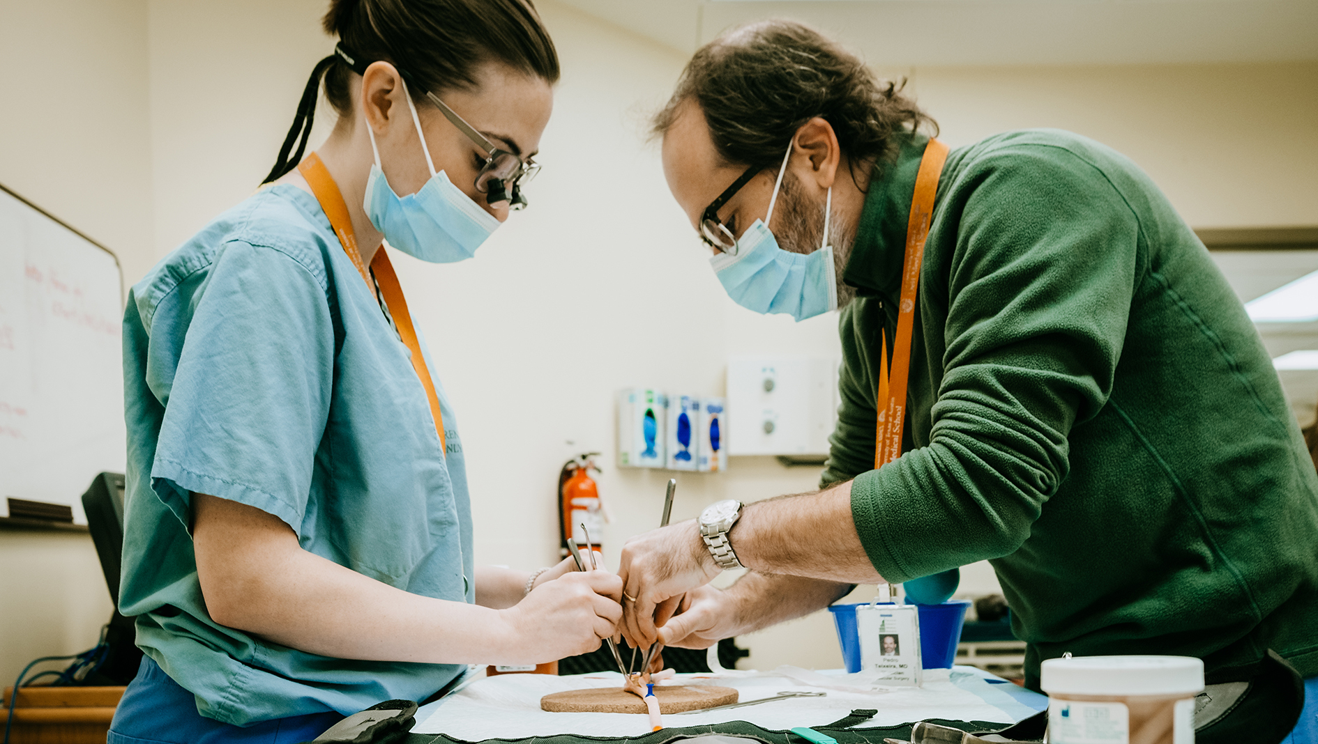 A surgery resident and faculty member working together during a simulation