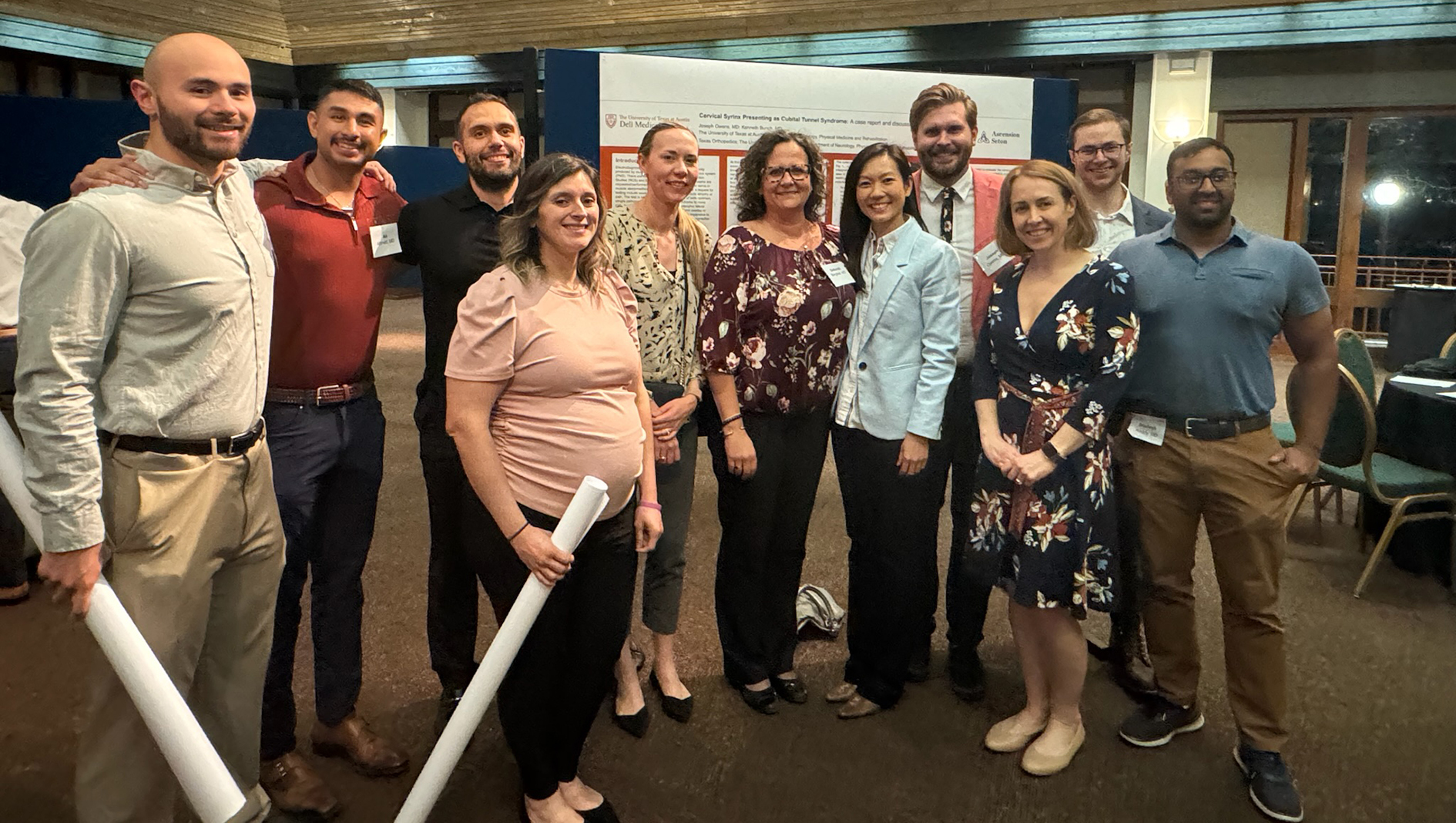 PM&R residents and faculty pose for a group photo at a research poster presentation.