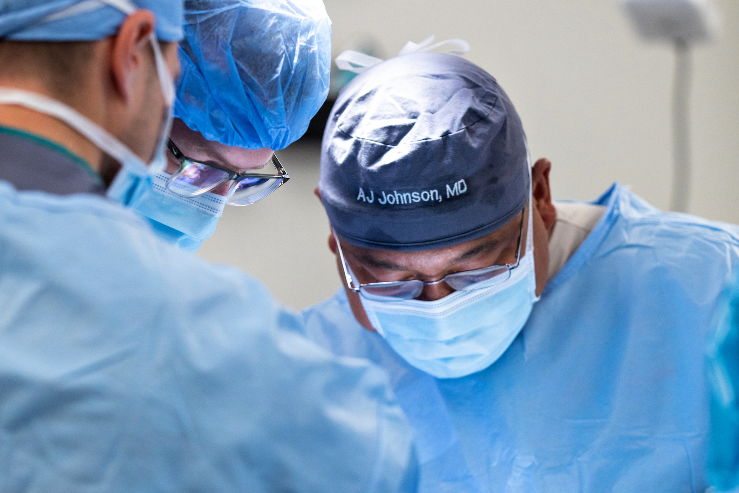 Two doctors performing surgery in an operating room.