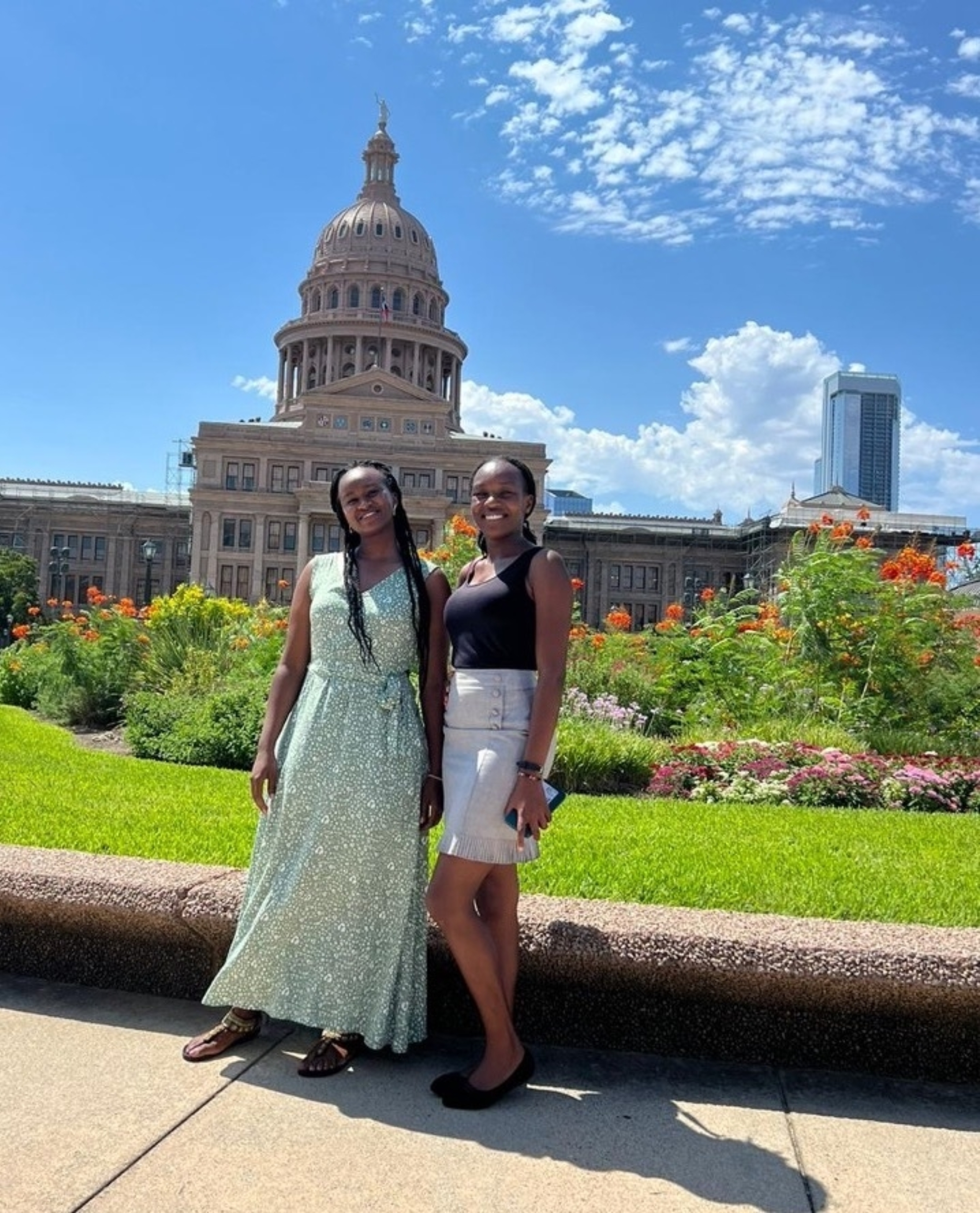 Two international exchange students from Kenya stand together for a photo outside the Texas state capitol building.