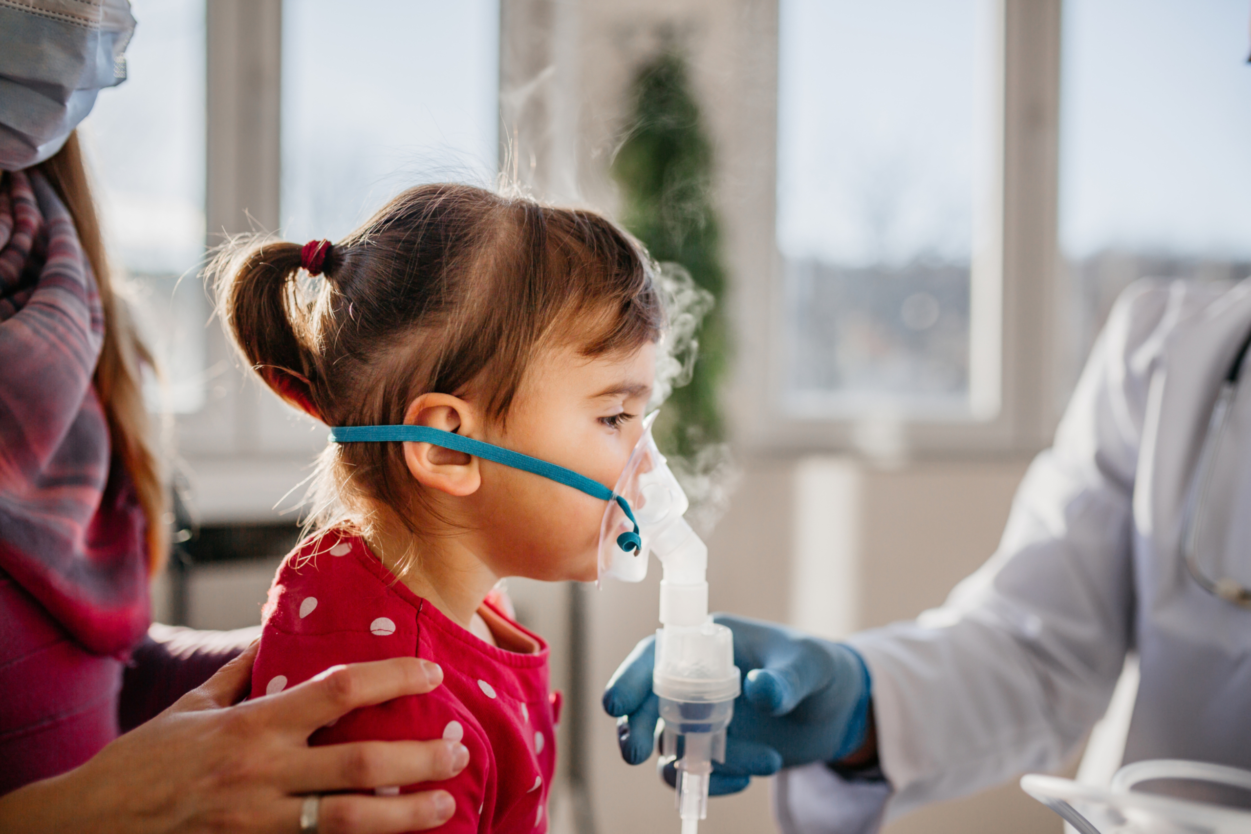 Little girl with asthma being treated with an inhaling mask.