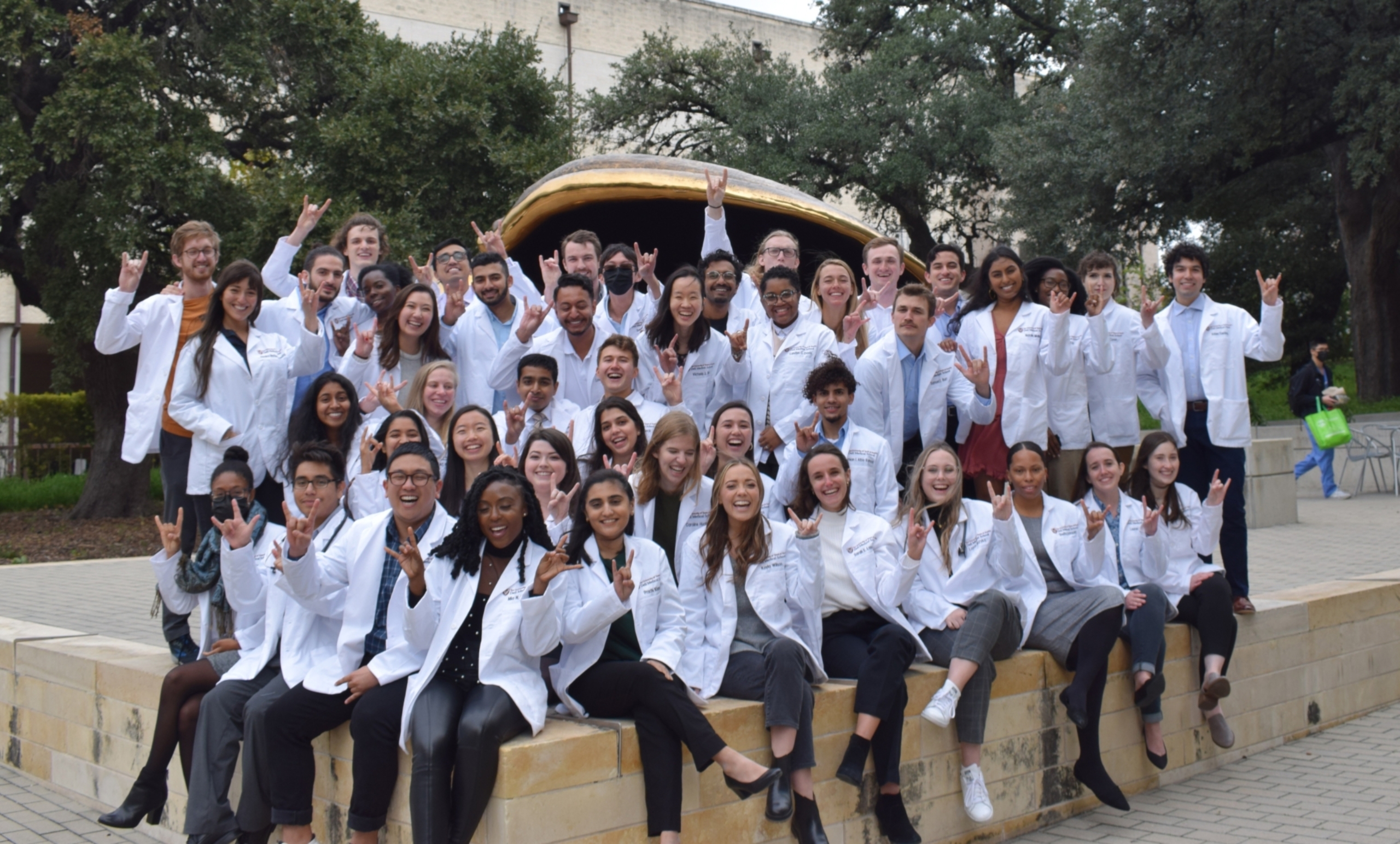 A group of medical students posing in front of an art installation on the Dell Med campus.