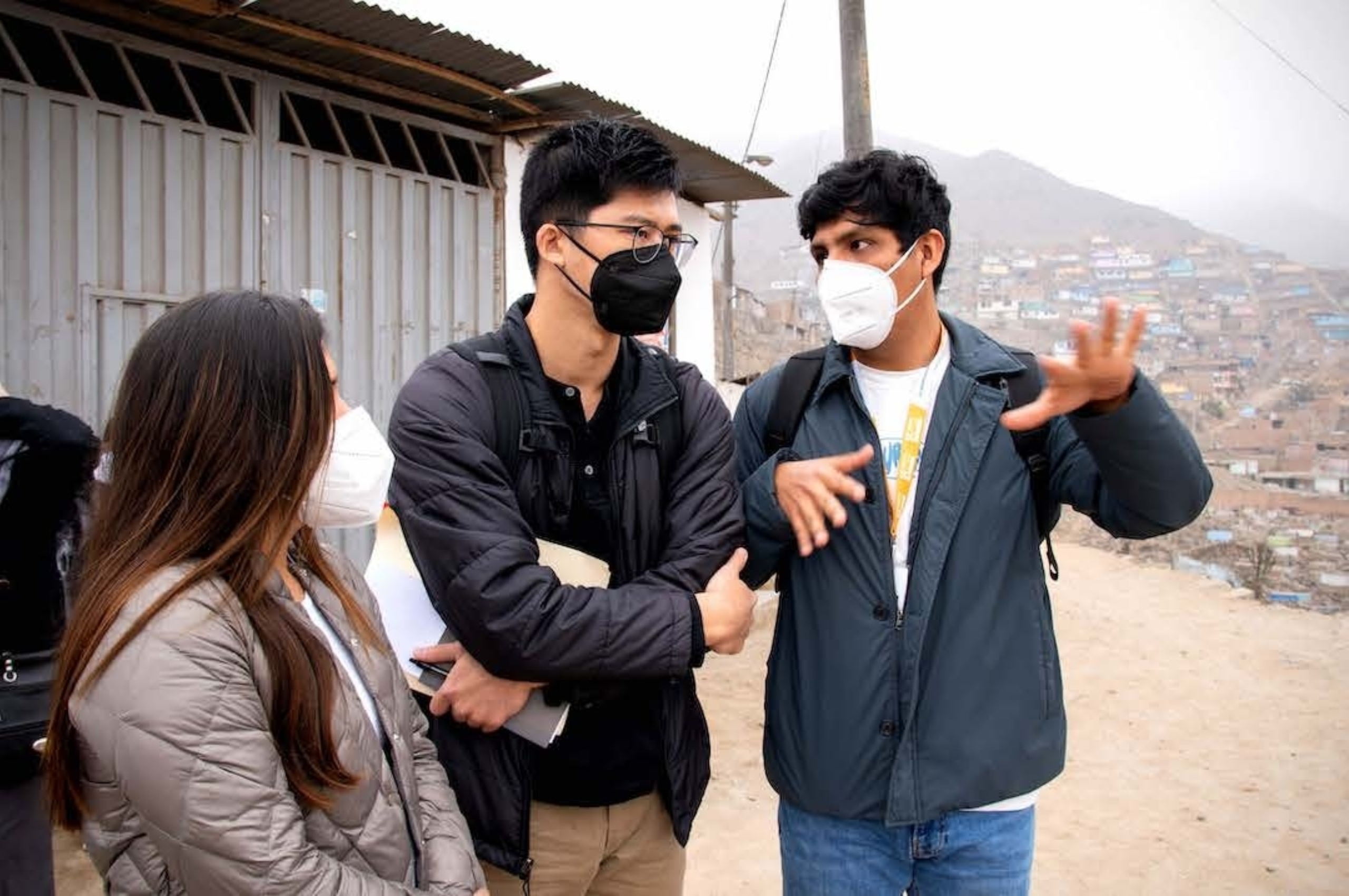 Image: Alexander Chu stands in a group of people wearing medical masks in Lima, Peru.
