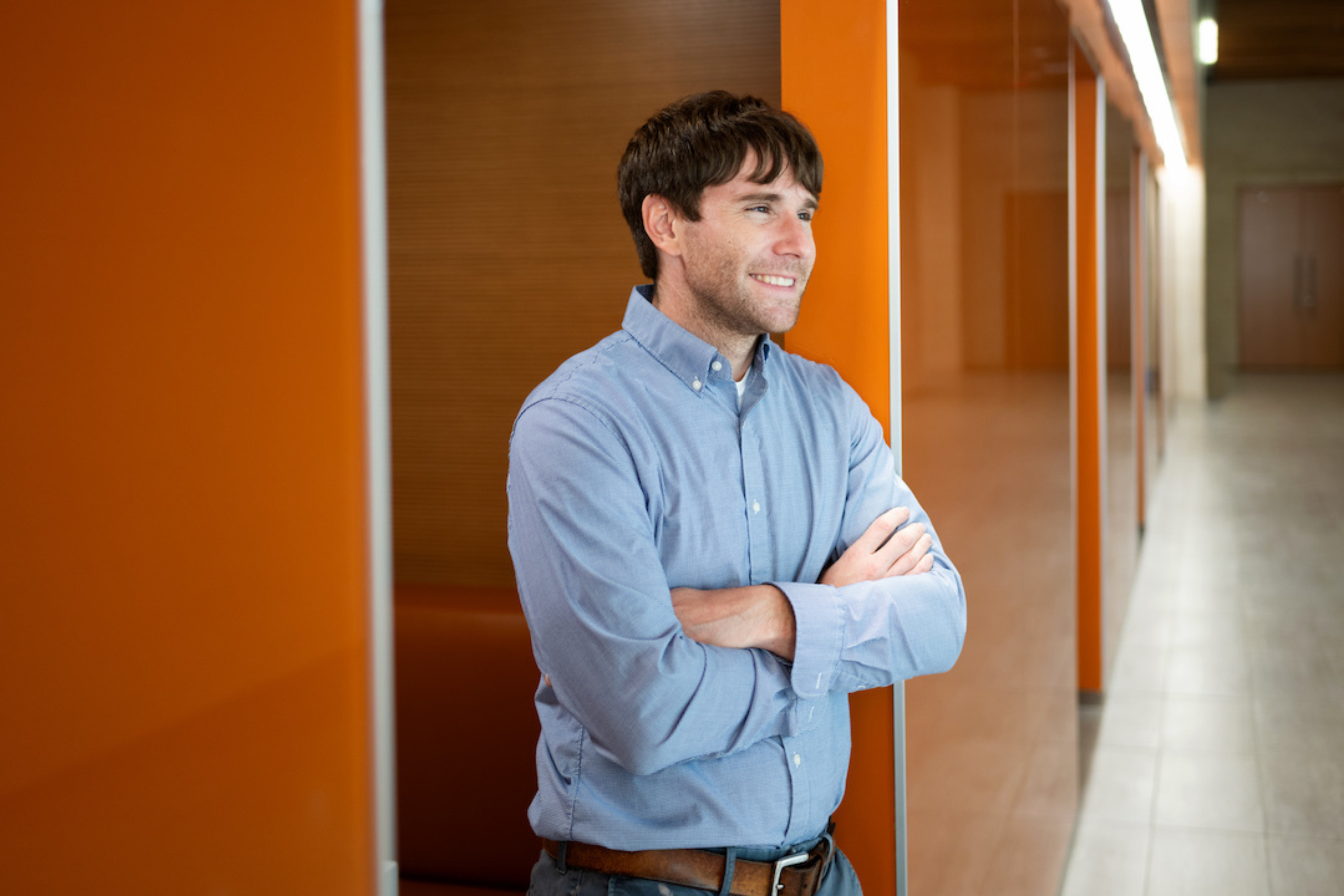 Benjamin Umlauf crosses his arms and stands for a portrait inside the Dell Med campus.