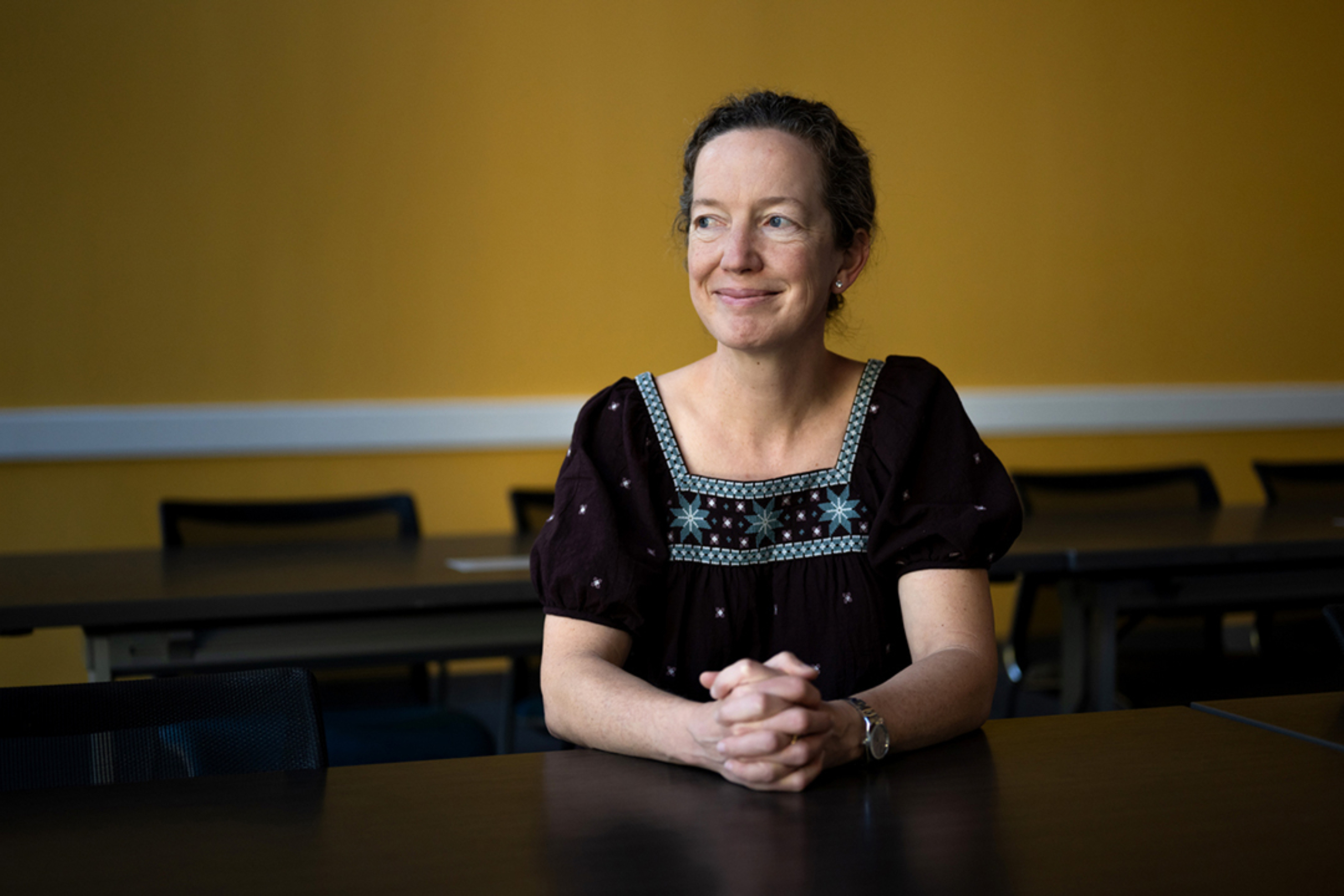 Portrait of Brooke Wagen sitting at a table with her hands crossed