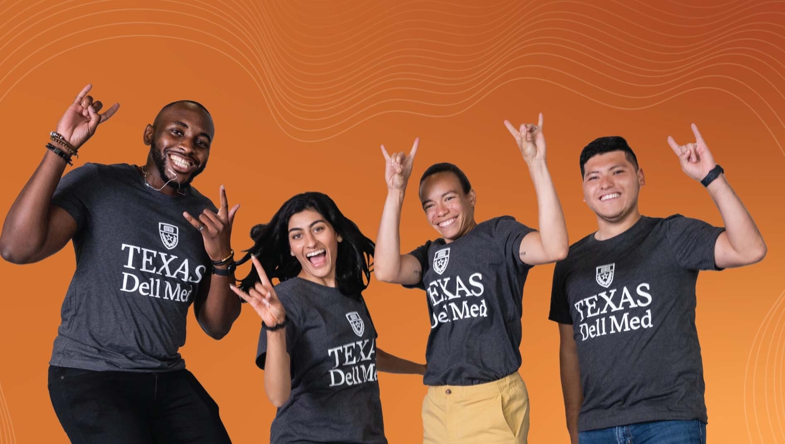 Four members of Dell Med's Class of 2027 jumping and holding up the "hook 'em" sign.