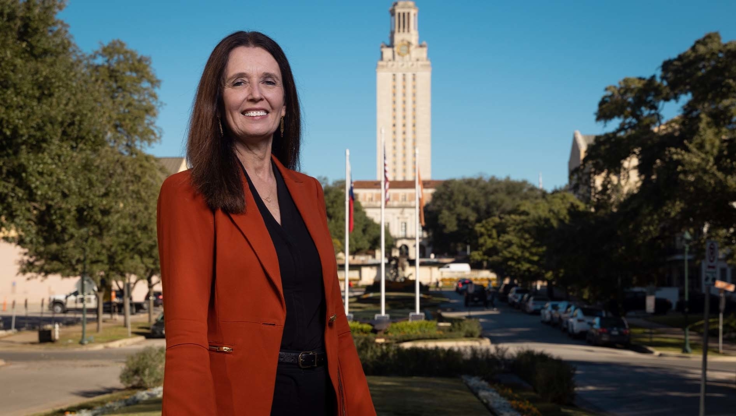 Claudia Lucchinetti stands for a portrait on the University of Texas at Austin campus. In the background, behind Lucchinetti, is the UT Tower in front of a blue sky.