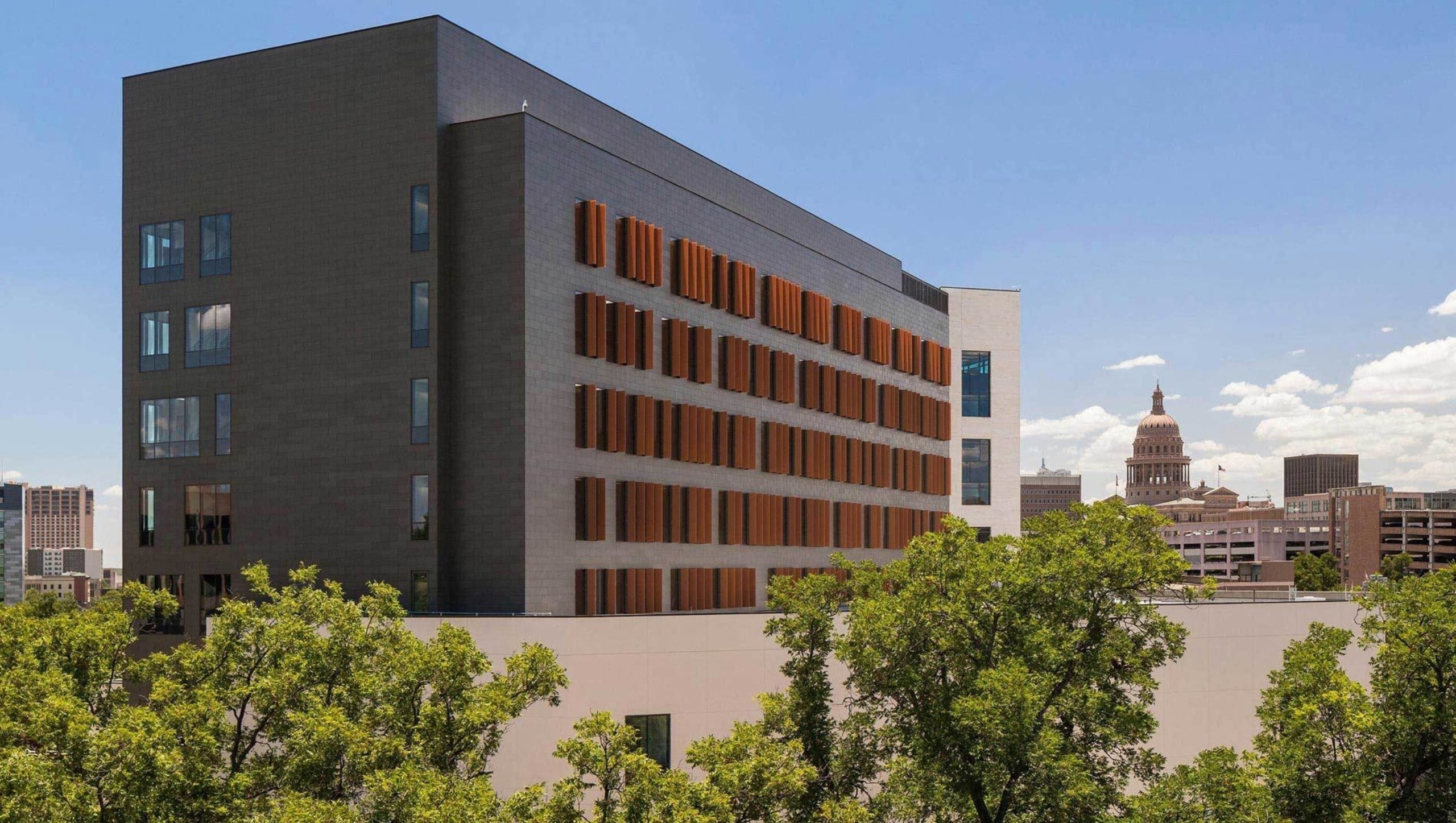 Dell Med Health Discovery Building with the Texas Capitol in the background.