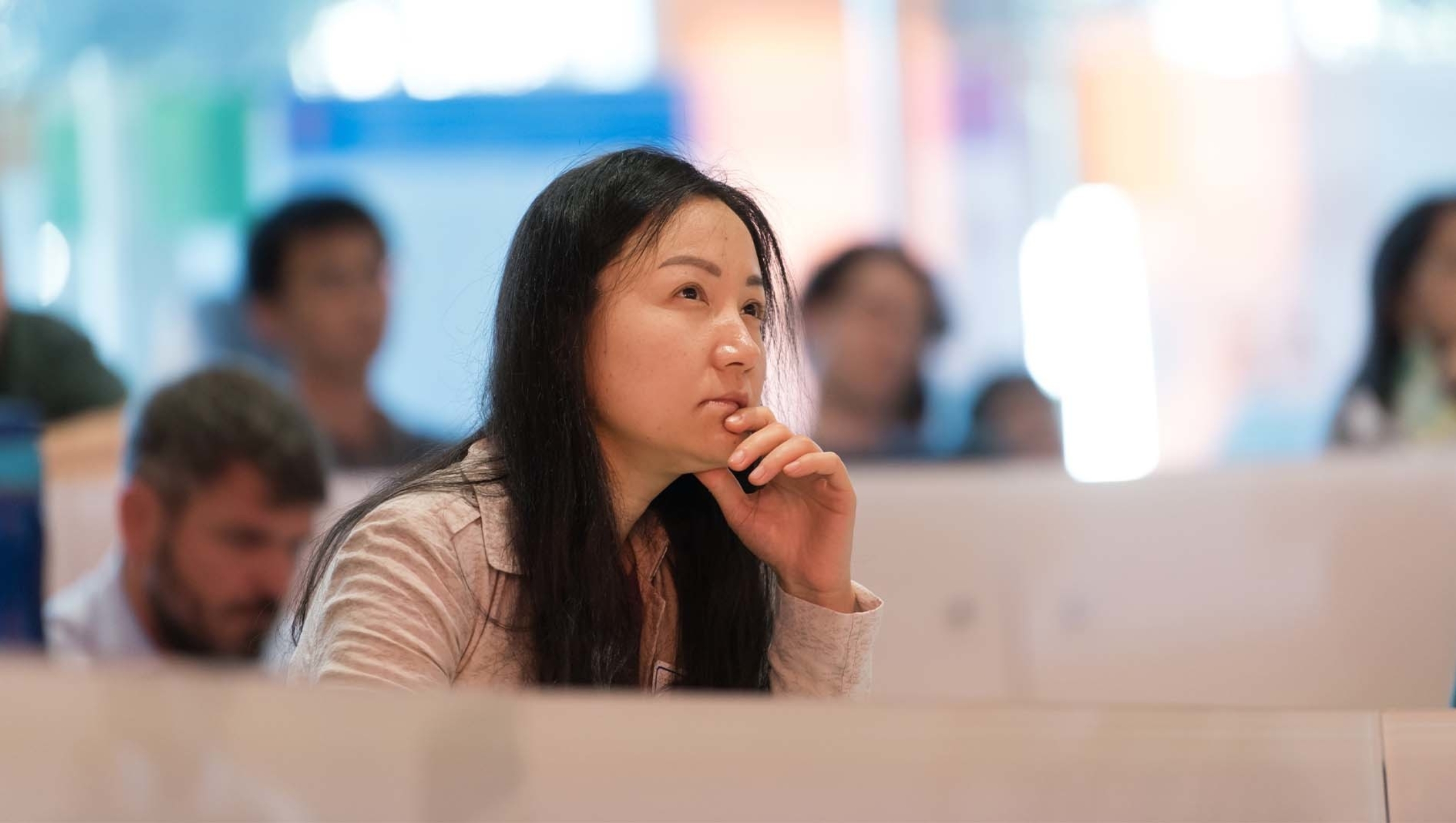 A women sitting among others in a Dell Medical School auditorium.