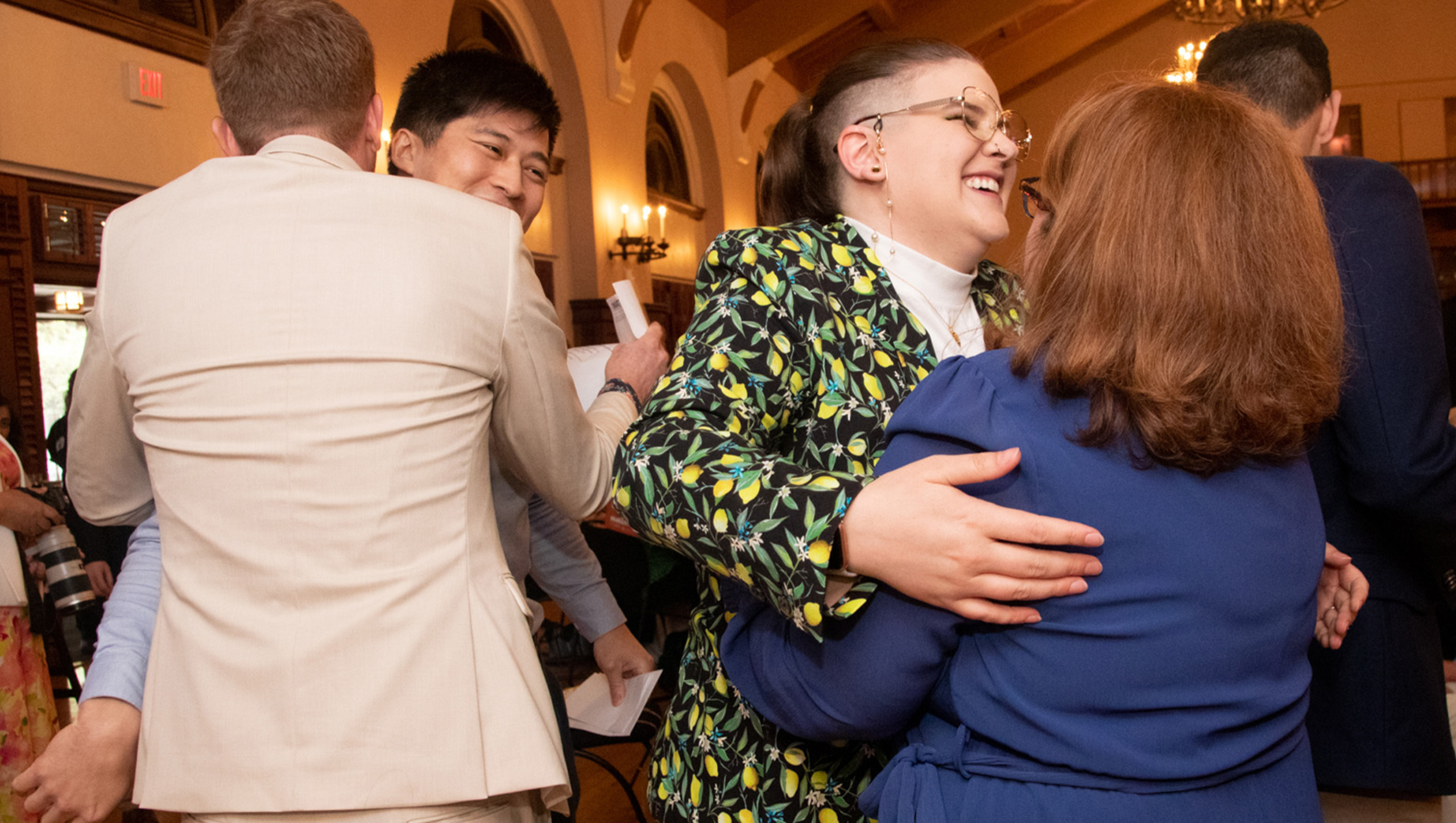 Two pairs of Dell Med students hug each other in celebration after learning where they will attend residency training.