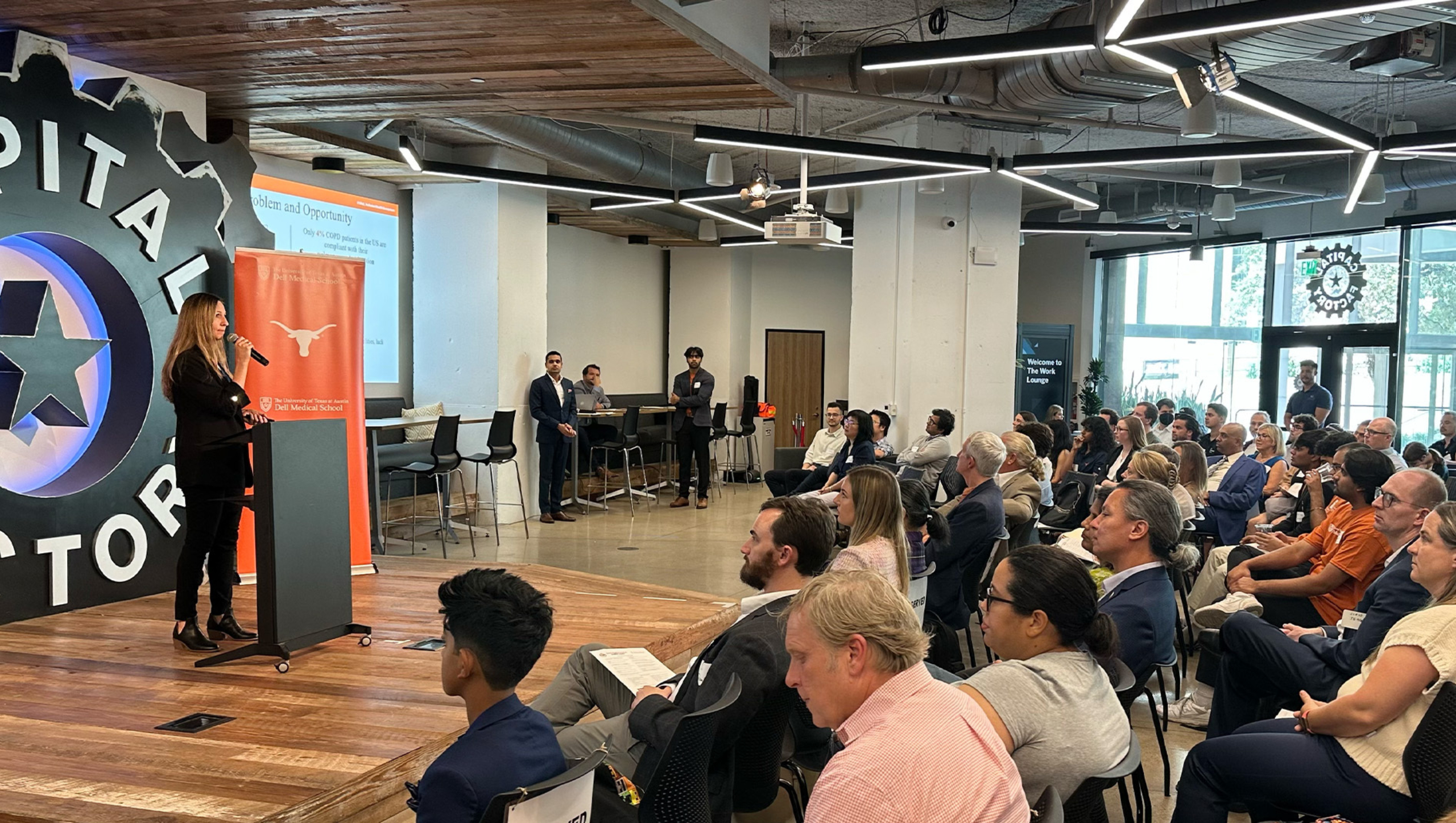 A woman delivers remarks to an audience as part of the Texas Health Catalyst Roundup and Rodeo event hosted at Capital Factory.