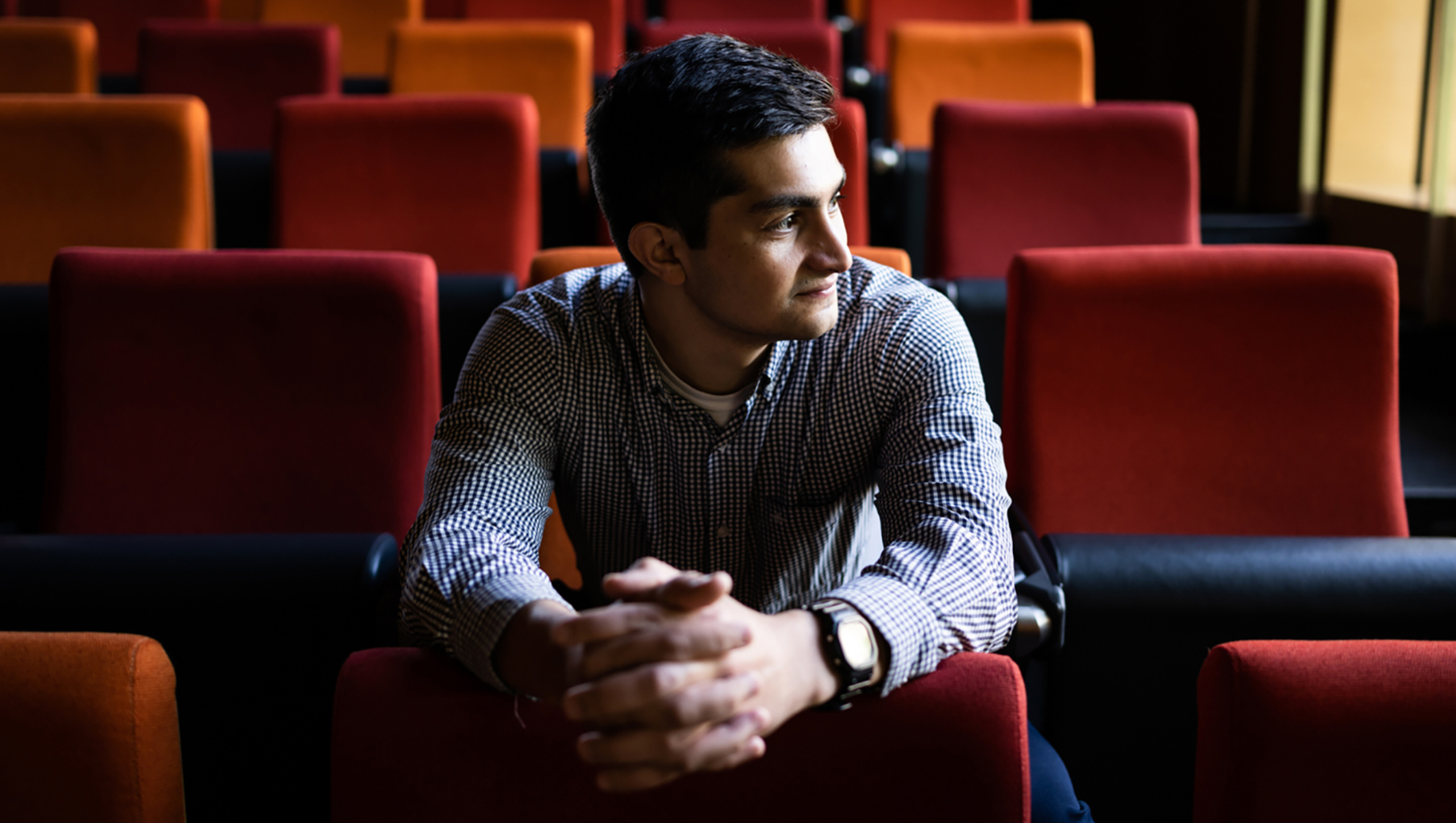 Portrait of Khalid Sheikh sitting inside an auditorium