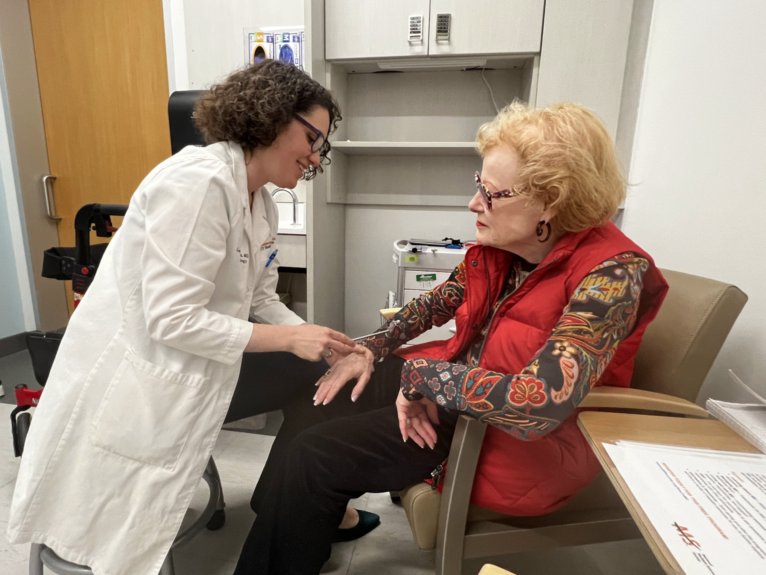 A doctor and patient converse in a doctor's office.