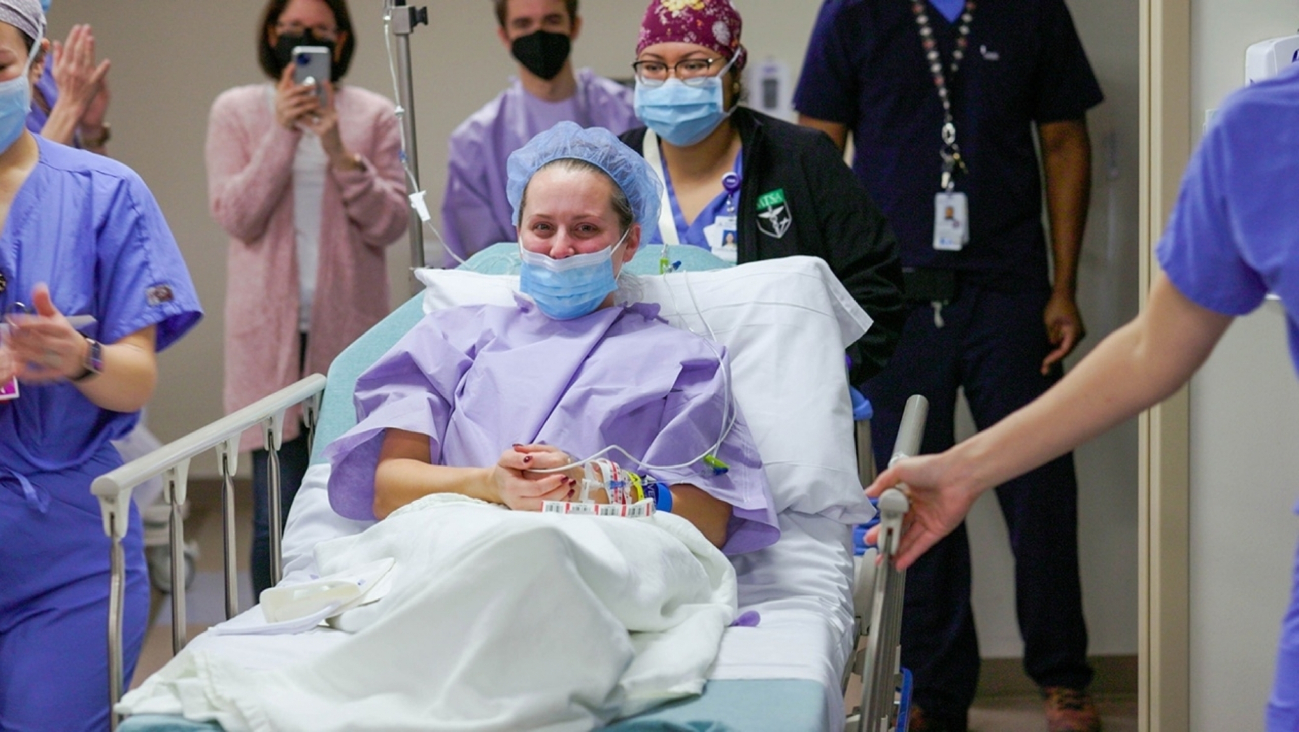 Living kidney donor, Kayla Wright, is applauded by caregivers of the Abdominal Transplant Center who line the halls as she travels from her room to the operating room for surgery.